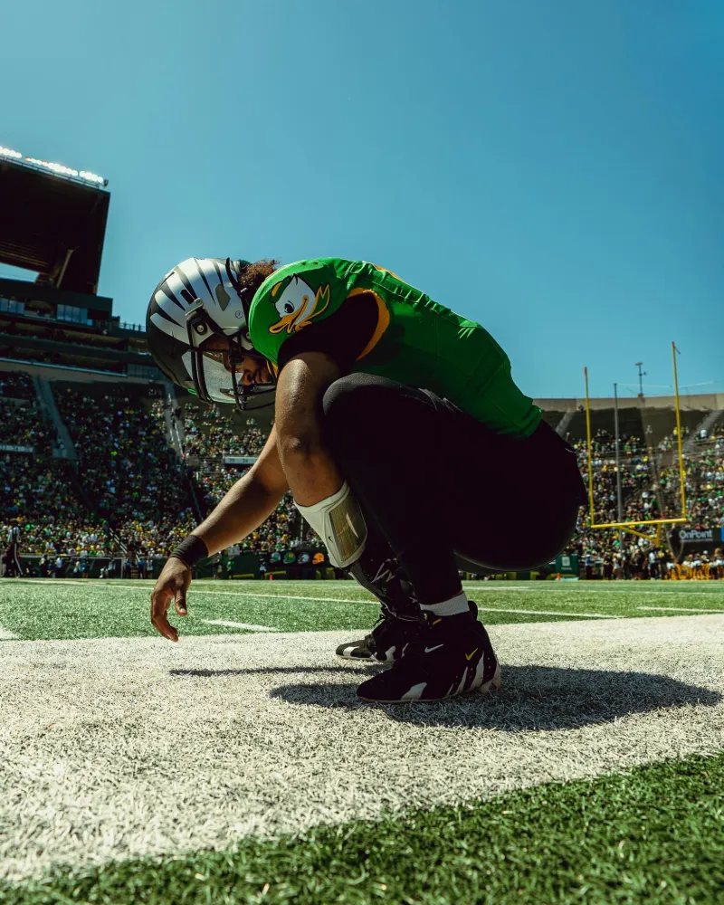 Dante Moore crouched in the Autzen Stadium end zone in Oregon green