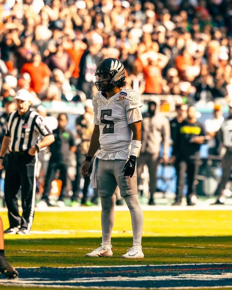 Dante Moore in Oregon's white away uniform on the field