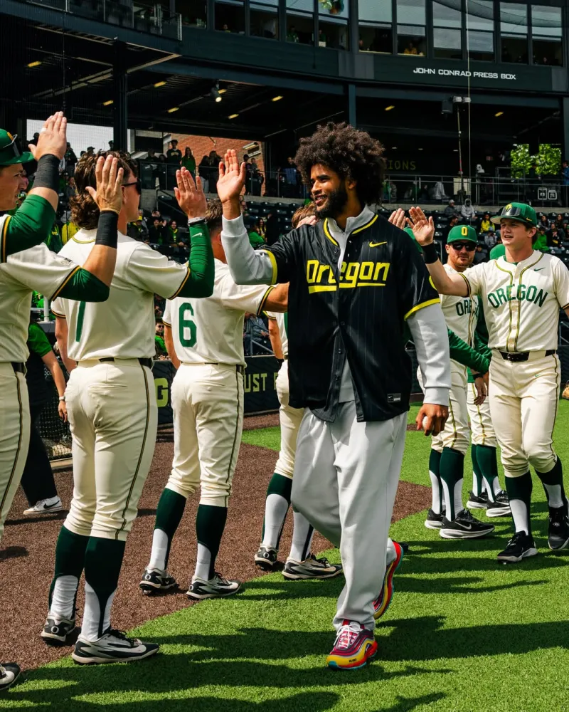 Dante Moore in an Oregon baseball jersey greeting the team