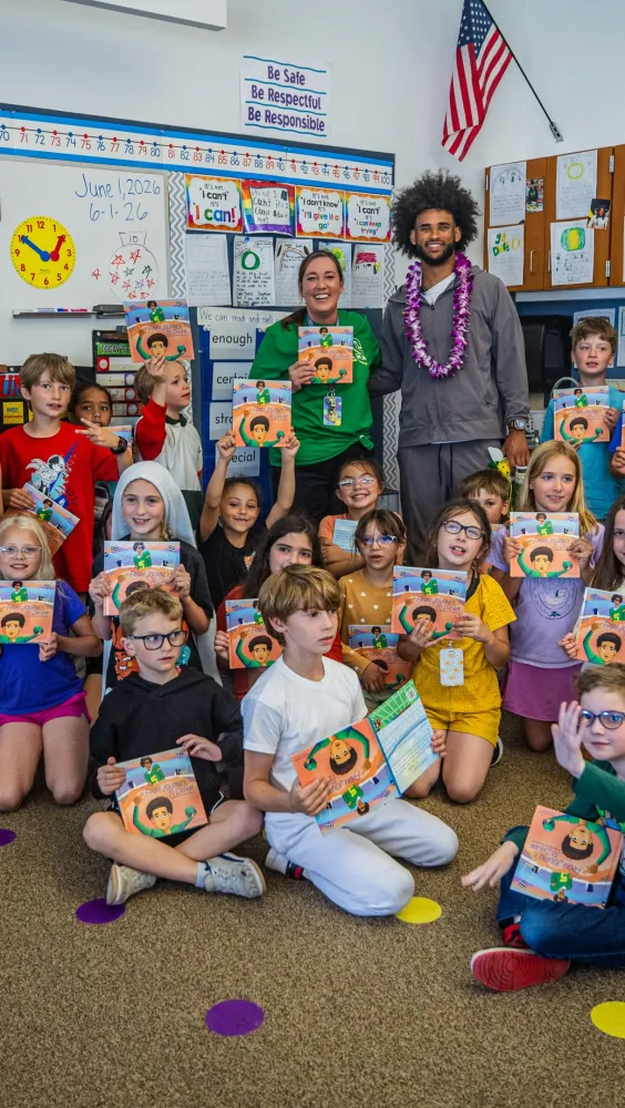 Dante Moore reading to elementary school students